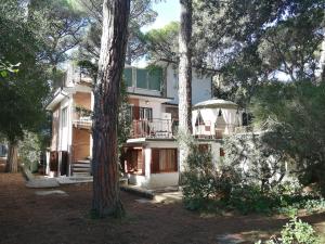 una grande casa in mezzo ad alcuni alberi di Vacanze Toscane In The Seaside a Marina di Castagneto Carducci