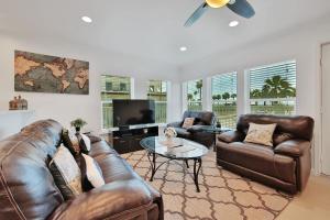 a living room with leather furniture and a flat screen tv at Oceanview by the Galvez in Galveston