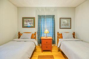 a bedroom with two beds and a table with a lamp at White Lobster Cottage in Greenville