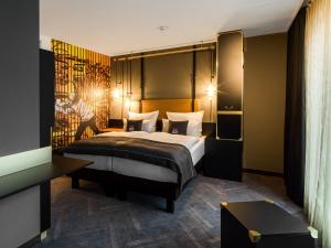 une chambre d'hôtel avec un lit et un homme assis sur lui dans l'établissement the niu Cobbles, à Essen