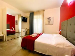 a bedroom with a large bed with a red wall at NEW Bcomfort in Cagliari