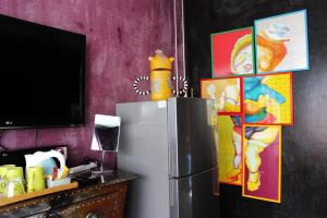 a refrigerator in a room with paintings on the wall at Villa Thapae in Chiang Mai