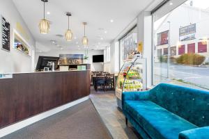 a restaurant with a blue couch in front of a counter at Comfort Hotel Fosna in Kristiansund