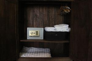 a closet with a shelf with towels and a microwave at Villa Thapae in Chiang Mai