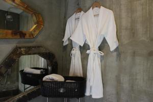 a robe hanging on a wall next to a mirror at Villa Thapae in Chiang Mai