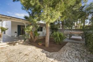 una casa con patio con tavolo e alberi di Villa LA CAPANNELLA a Nardò