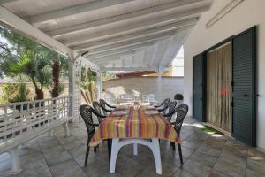 un tavolo da pranzo e sedie su un patio di Villa LA CAPANNELLA a Nardò