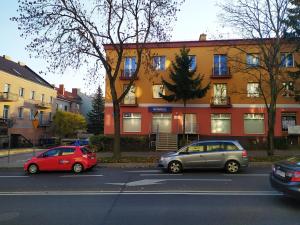 dwa samochody zaparkowane przed budynkiem w obiekcie Nordic Apartamenty Grochowa w mieście Białystok