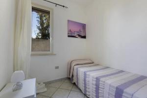 una camera bianca con un letto e una finestra di Villa LA CAPANNELLA a Nardò