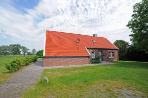 uma pequena casa de tijolos com um telhado laranja em Ferienhaus Adamla, 65319 em Moormerland