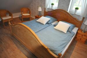 um quarto com uma cama de madeira e 2 almofadas em Ferienhaus Adamla, 65319 em Moormerland