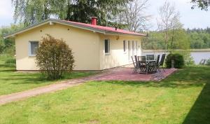 ein Haus mit einem Tisch und Stühlen im Hof in der Unterkunft Ferienhäuser Seewiesen in Reimershagen
