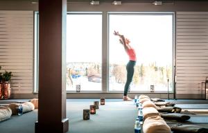une femme faisant une pose de yoga devant une fenêtre dans l'établissement Storhogna Högfjällshotell & Spa, à Storhågna