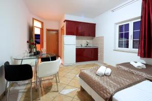 a small room with a kitchen and a dining room at Pink House Apartments in Novalja