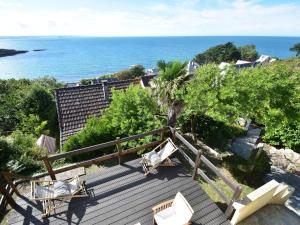 une terrasse avec des chaises et l'océan en arrière-plan dans l'établissement Scenic Holiday Home in Fermanville near Sea, à Fermanville