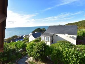 - une vue sur une maison avec l'océan en arrière-plan dans l'établissement Scenic Holiday Home in Fermanville near Sea, à Fermanville