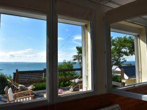 duas janelas num quarto com vista para o oceano em Scenic Holiday Home in Fermanville near Sea em Fermanville