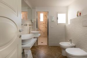 a white bathroom with two sinks and two toilets at Residenza Conte di Cavour & Rooftop in Florence