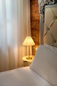a bed with a lamp on a table next to it at Residenza Conte di Cavour & Rooftop in Florence