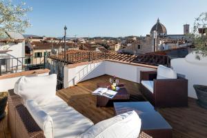 a balcony with white furniture and a view of the city at Residenza Conte di Cavour & Rooftop in Florence