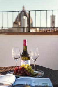 a bottle of wine and two glasses on a table at Residenza Conte di Cavour & Rooftop in Florence