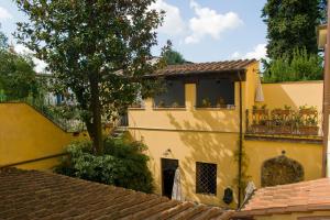 a yellow house with a balcony and a tree at Residenza Il Villino B&B in Florence