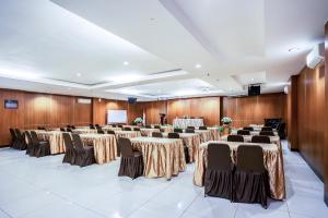 uma sala de conferências com mesas e cadeiras e um pódio em Hotel Grand Kartika em Samarinda