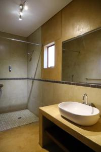 a bathroom with a sink, mirror, and bathtub at Cest Si Bon Hotel in Otjiwarongo