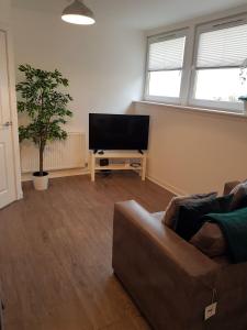 a living room with a couch and a flat screen tv at Carvetii - Edward House C - 2 Dbl bed 2nd floor flat in Dunfermline