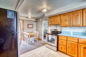 a kitchen with wooden cabinets and a dining room with a table at Beaches Inn | Buccaneer Bay Bungalow in Cannon Beach
