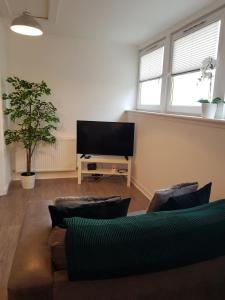 uma sala de estar com um sofá e uma televisão de ecrã plano em Carvetii - Edward House C - 2 Dbl bed 2nd floor flat em Dunfermline