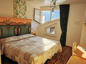 sypialnia z łóżkiem i oknem w obiekcie Lago Park Hotel w mieście Molveno