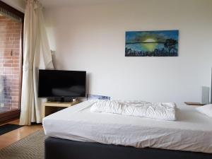 een slaapkamer met een bed en een flatscreen-tv bij Apartment am Hafen in Travemünde
