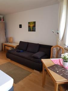 a living room with a black couch and a table at Apartment am Hafen in Travemünde