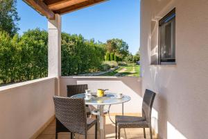 a patio with a table and chairs on a balcony at House Casetta Filip in Krnica