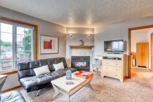 a living room with a black leather couch and a fireplace at Beaches Inn | Puffins Place Cabana in Cannon Beach