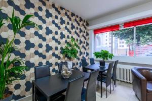 un restaurant avec deux tables et chaises et un mur à motifs dans l'établissement Comfort Hotel Rouen Alba, à Rouen