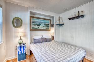 ein Schlafzimmer mit einem Bett und einem Bild an der Wand in der Unterkunft Baerfoot Bungalow in Cannon Beach