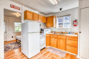 cocina con armarios de madera y nevera blanca en Baerfoot Bungalow en Cannon Beach