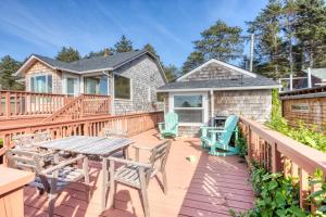 a deck with a table and chairs and a house at Baerfoot Bungalow in Cannon Beach