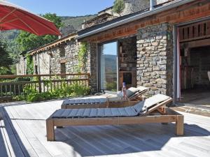 2 tumbonas en una terraza de madera con un edificio en Inviting Villa in Ayguatebia Talau with Garden, en Talau