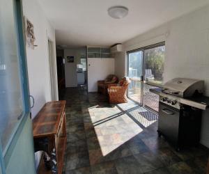 a kitchen with a table and a stove in a room at Number 1 Beach House in Rainbow Beach