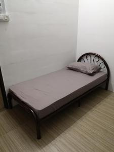 a bed sitting in a corner of a room at Homey Hostel in Ipoh