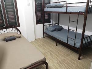 a room with two bunk beds and a bench at Homey Hostel in Ipoh