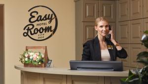 a woman talking on a phone at a desk with a laptop at Easy Room in Nizhny Novgorod