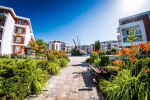 una pasarela por una ciudad con edificios y flores en Privillege Fort Noks Beach Apartments, en Elenite