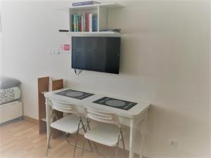 ラスパルマス・デ・グランカナリアにあるMini Flatの白いテーブル(椅子付)、壁掛けテレビ
