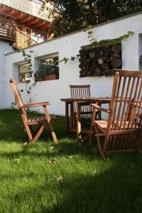 2 chaises en bois et une table dans l'herbe dans l'établissement Johanneshof Gästehaus, à Hockenheim