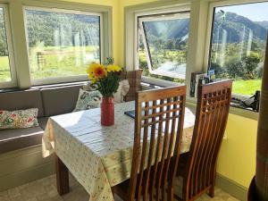 a dining room table with a vase of flowers on it at Nan's Cottage in Beauly