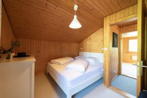 ein Schlafzimmer mit einem weißen Bett in einem Holzzimmer in der Unterkunft Schwendiblick in Wildhaus